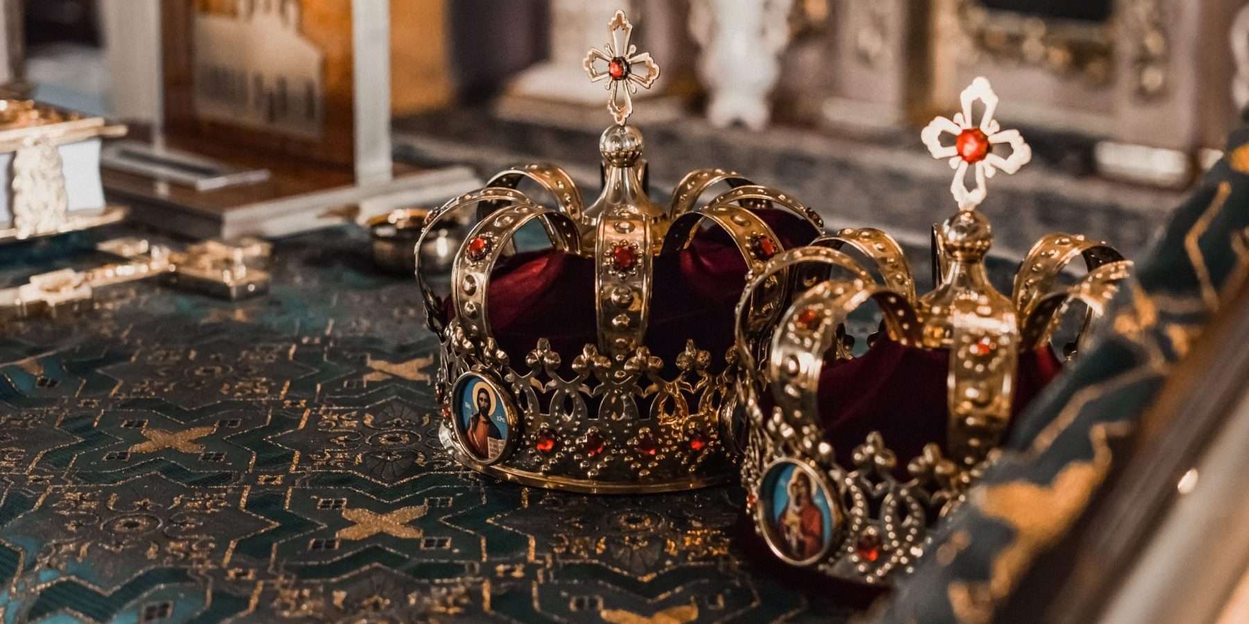 Dos coronas doradas con piedras preciosas sobre una mesa en una iglesia, símbolo del Nakshatra Maghā en la astrología védica