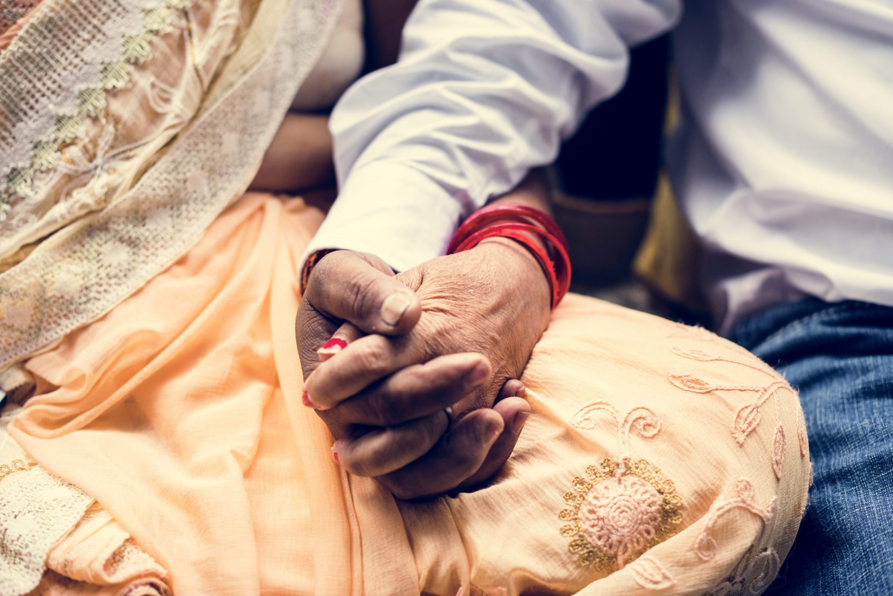 Manos entrelazadas de una pareja india sentada, símbolo del Nakshatra Uttara Phalgunī en la astrología védica