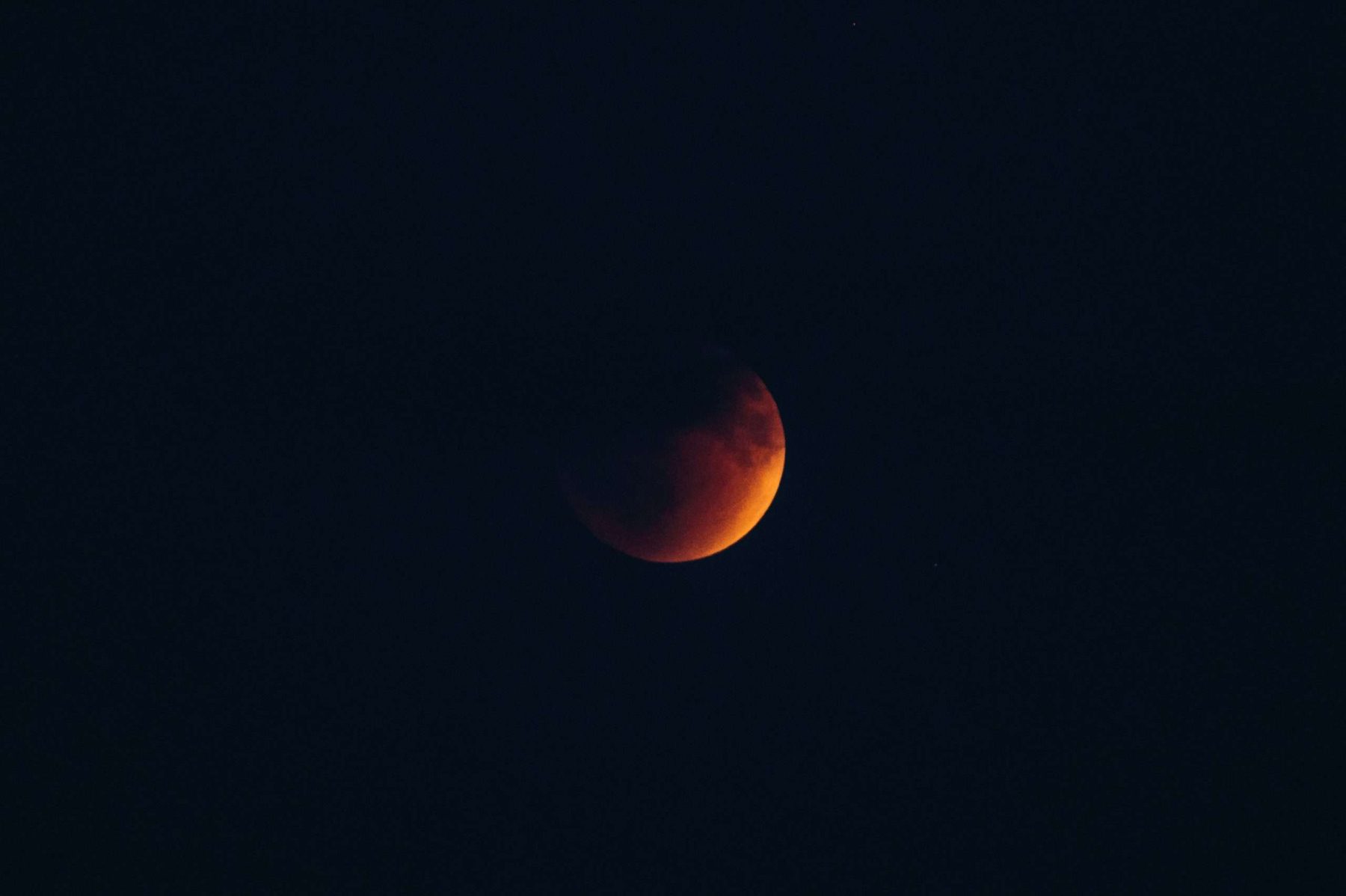Luna rojiza en sombra sobre fondo oscuro, imagen para artículo sobre Rāhu y Ketu en Jyotiṣa